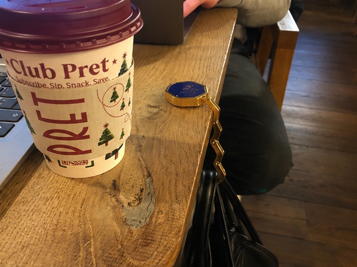 HERUNO HALO Fold hanging from a table edge next to a coffee cup